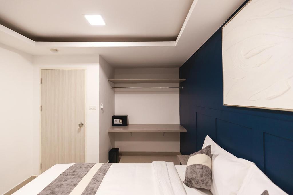 A double room corner with a narrow desk, open hanging rail, safe, and blue accent wall.