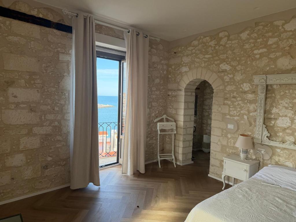 a bedroom with a bed and a view of the ocean at Suite Mare Selene - Il Monastero Sul Mare in Vieste