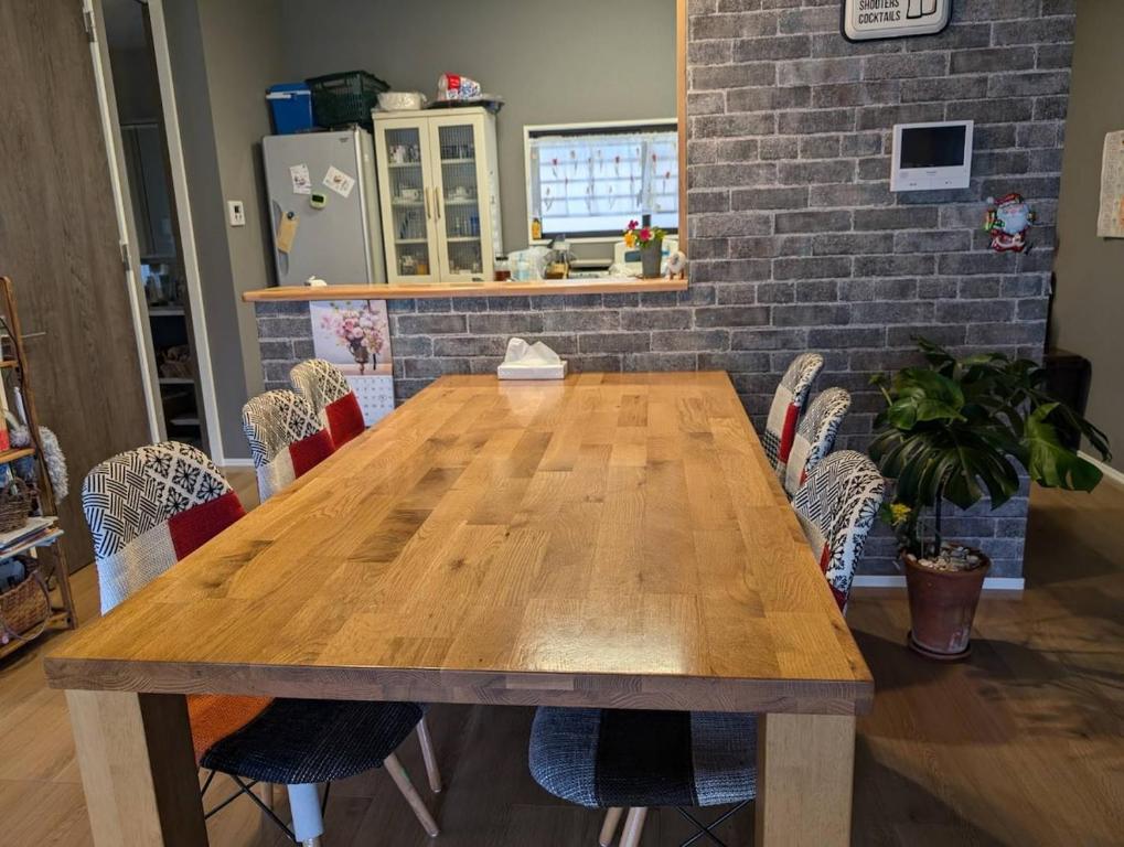 a wooden table and chairs in a room at Nago city 民泊U in Nago