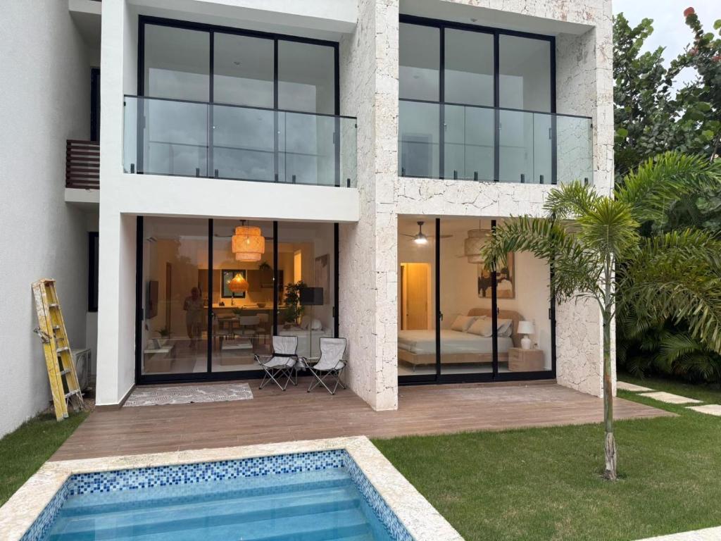 a house with a swimming pool and a bedroom at Cocotal 2beds apartament Golf Course Melia Beach PC RD in Punta Cana