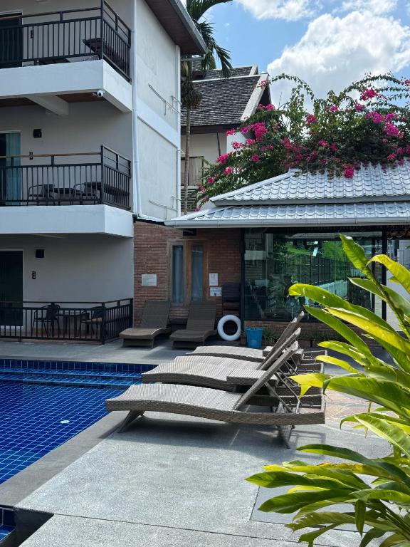 A compact pool deck sits beside balconies and flowering tropical plants.