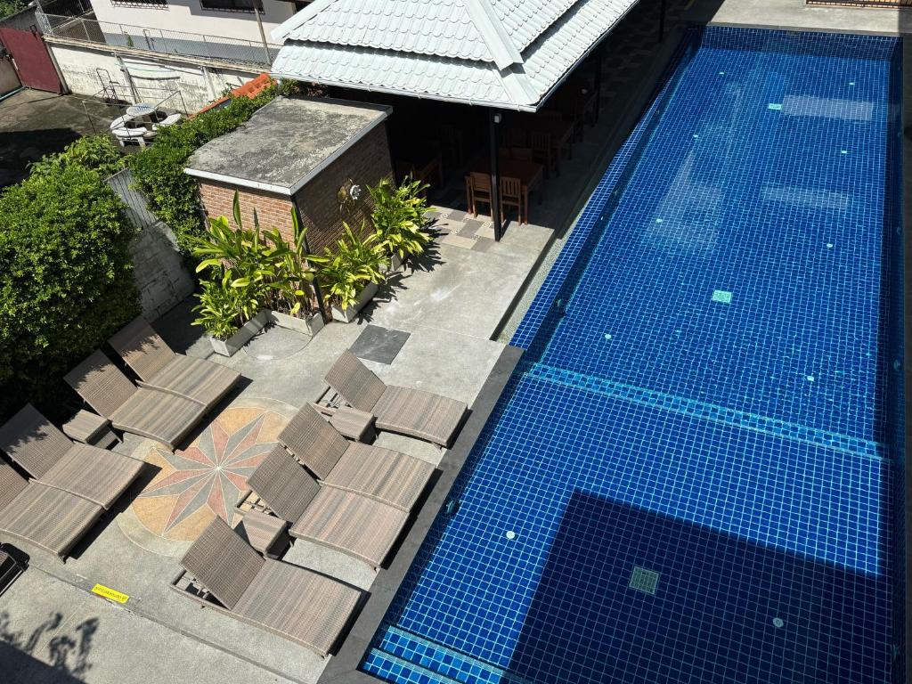 A rooftop-style overhead view of the blue-tiled pool and surrounding loungers.