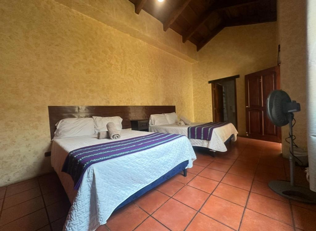 a bedroom with two beds in a room at Casa Los Héroes in Antigua Guatemala