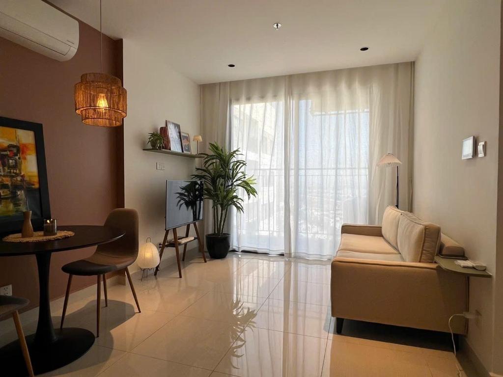 een woonkamer met een bank en een tafel bij The Urban Origami S703 in Long Bình