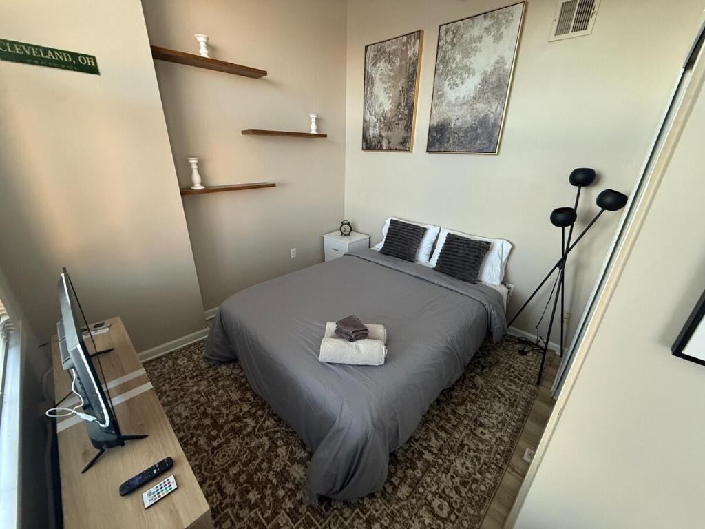 a small bedroom with a bed and a television at Downtown Loft Free Street Parking Gym w Sauna in Cleveland