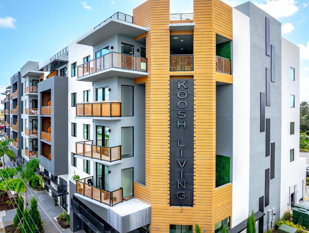a rendering of a building with a yellow facade at KOOSH - Boutique Aparthotel in Fort Lauderdale