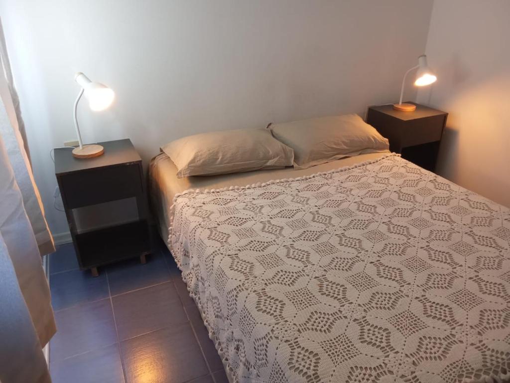 a bedroom with a bed with two night stands and two lamps at Costa Pinar in El Pinar