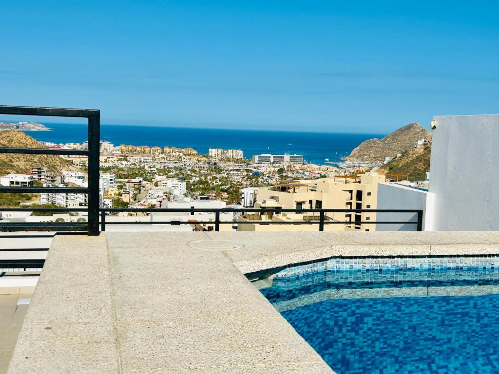 カボ・サン・ルーカスにあるBRAND NEW CONDO Cabo San Lucasの海の景色を望む建物の最上階にスイミングプールがあります。