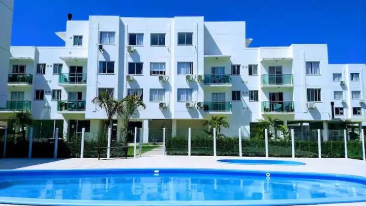 a building with a swimming pool in front of a building at Apartamento próximo praia in Florianópolis