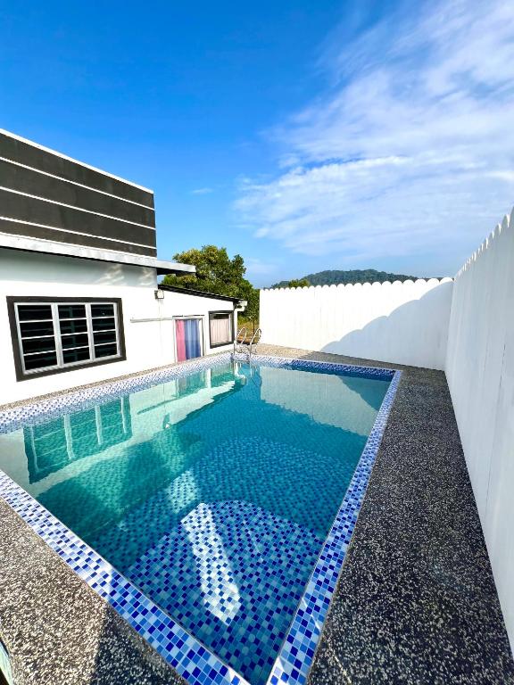 a swimming pool in front of a white house at CFD HOMESTAY PB Dungun Private Pool in Dungun