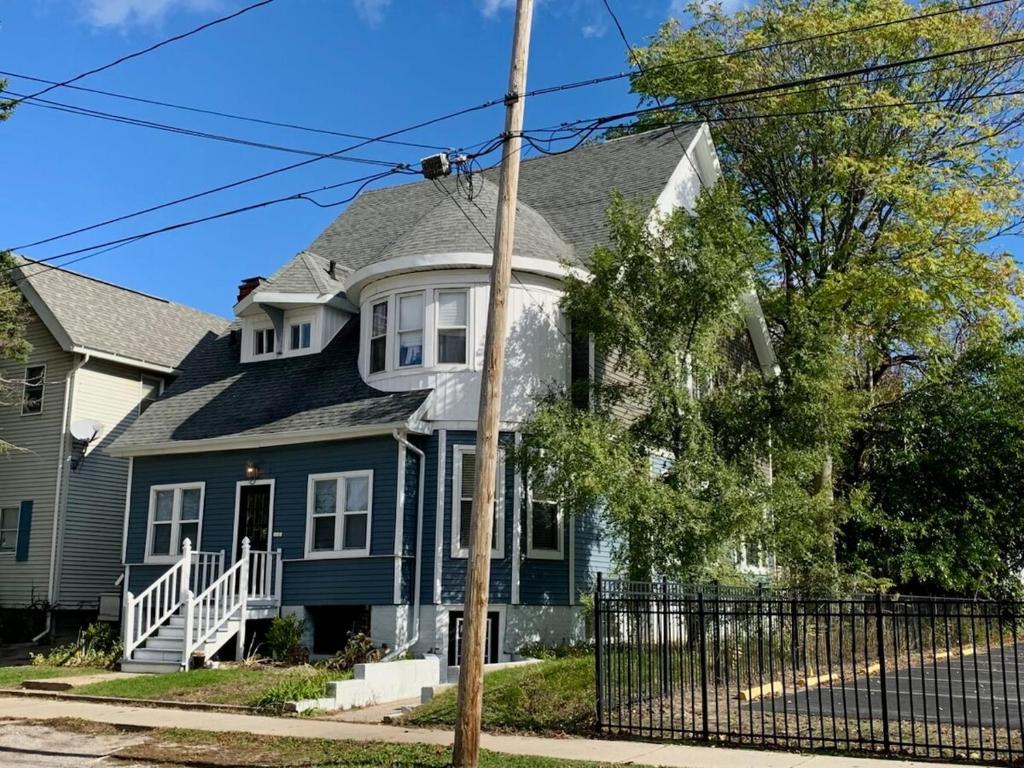 une maison bleue avec un toit gris dans l'établissement Beautiful Victorian Apartment, à Bay City