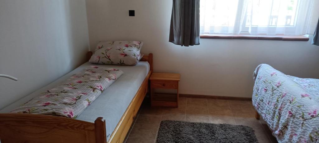 a small bedroom with a bed and a window at Dovolenkový dom na juhu Slovenska in Jahodná