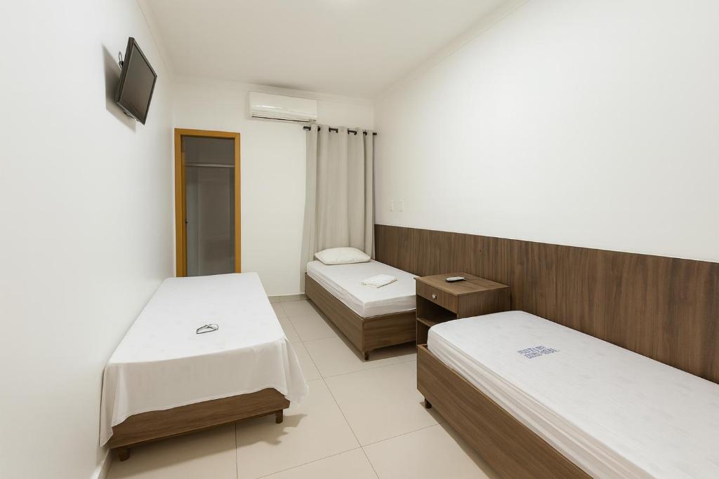 a hospital room with two beds and a mirror at Nova Jerusalém Hotel in Goiânia