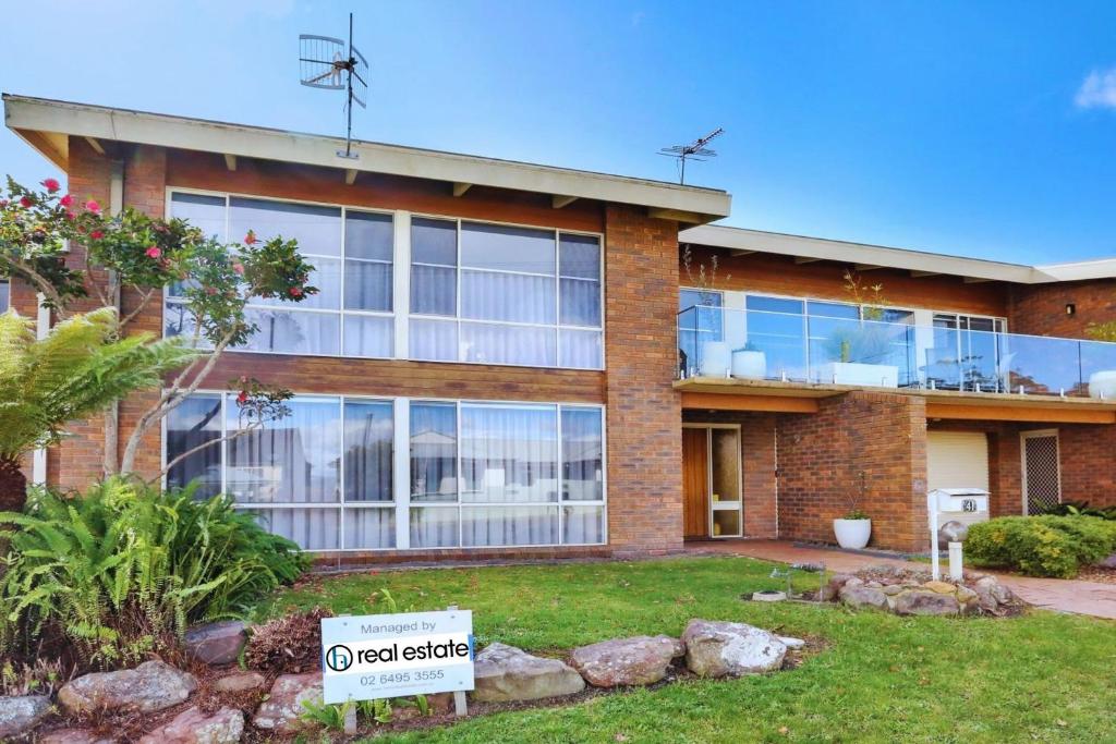 a brick house with a sign in front of it at 41 Collins Street Merimbula in Merimbula
