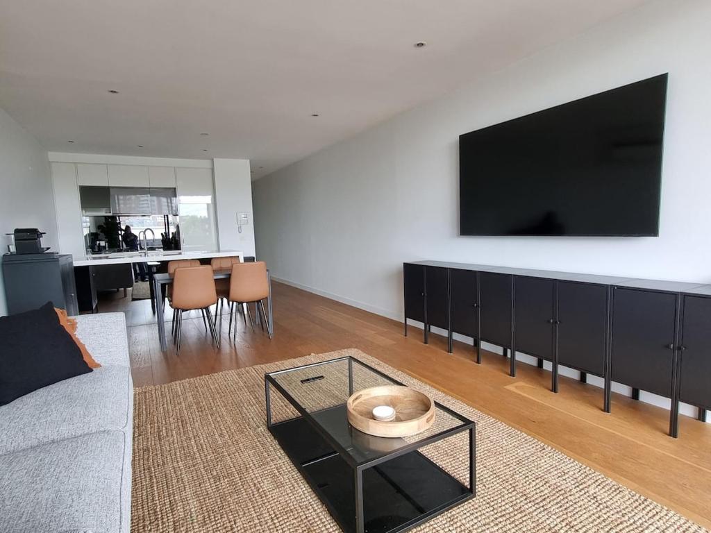 a living room with a couch and a flat screen tv at It's Melbourne - by the Beach! in Melbourne