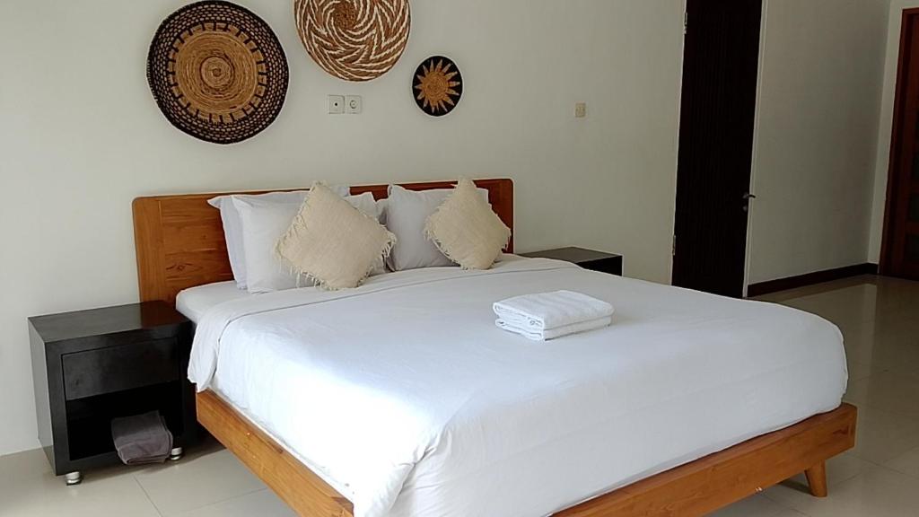 a bedroom with a large bed with white sheets and pillows at casavina studio 304 private kitchen, Near beach in Canggu