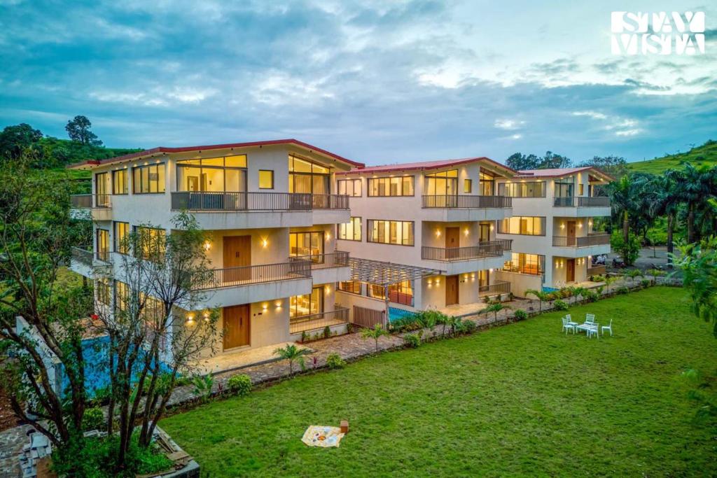 an exterior view of a building with a yard at StayVista at Mount Brook with Mountain views, AC, Lawn in Igatpuri