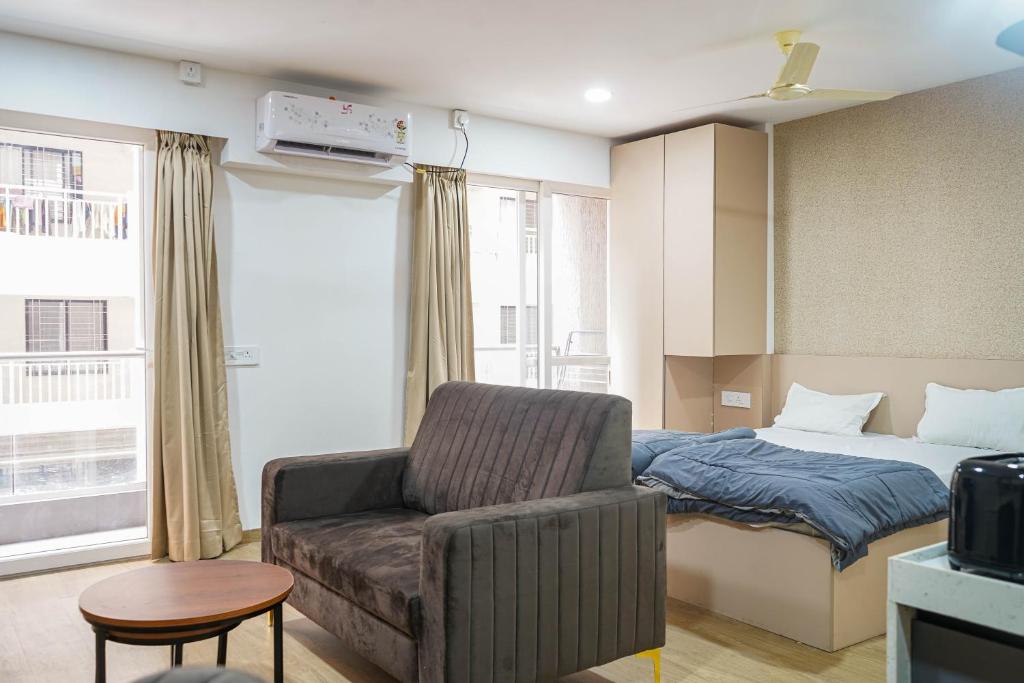 una sala de estar con un sofá y una cama en Cozmo Studio, Next to Pune Airport, en Pune