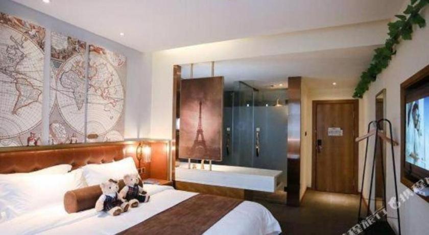 dos ositos de peluche sentados en una cama en un dormitorio en James Joyce Coffetel Nanchang West Station Nanchang University, en Xinjian