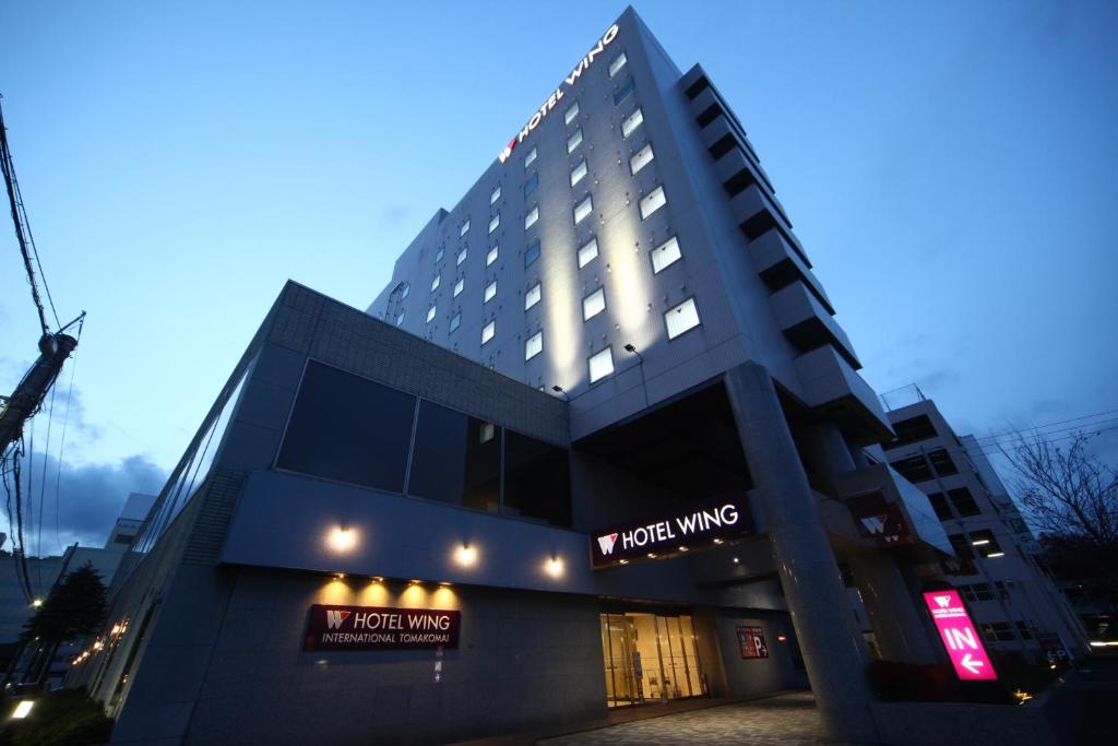 a hotel building with a sign on it at Hotel Wing International Tomakomai in Tomakomai