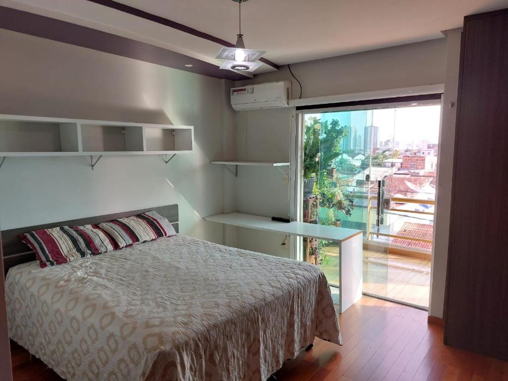 a bedroom with a bed and a large window at Cobertura COP30 in Belém