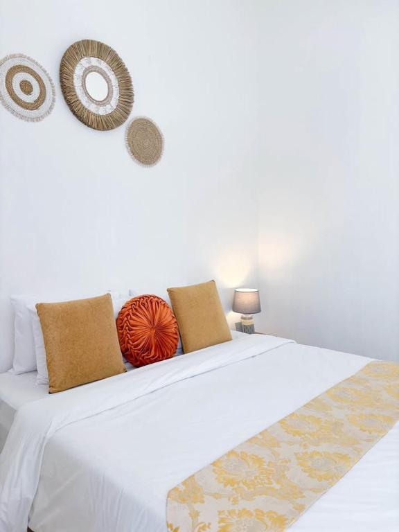 a white bed with two pillows on top of it at Yan Loft in Uluwatu