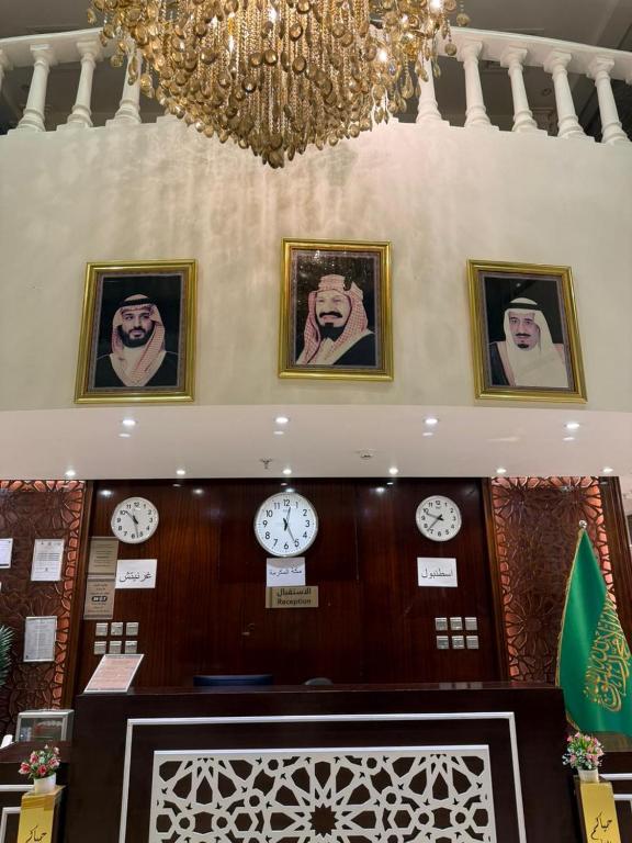 a room with clocks on the wall and a chandelier at فندق الروضة قريب من حفلات توصيل للحرم مجاناً in Al Khansāk