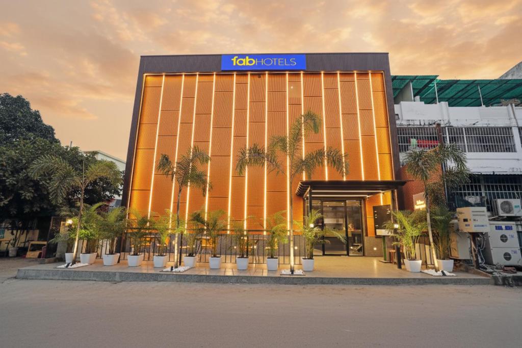 a building with palm trees in front of it at FabHotel Yellow Courtyard in Bhopal