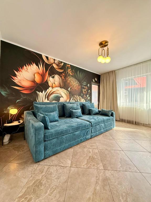 a blue couch in a living room with a mural at Billy&Ane Apartments,Rooms in Sinaia
