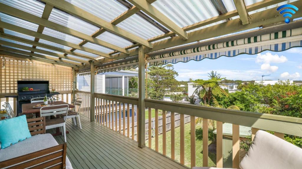 a screened porch with a pergola and a television at King Stingray in Currarong