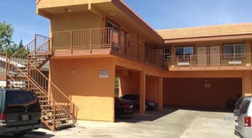 a house with a staircase in a parking lot at Coast Motel in Signal Hill