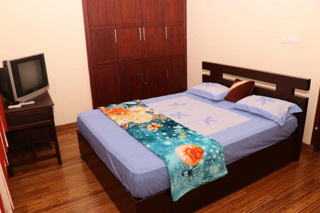 a small bedroom with a bed and a tv at Athithi Inn Homestay in Vaduvanchal
