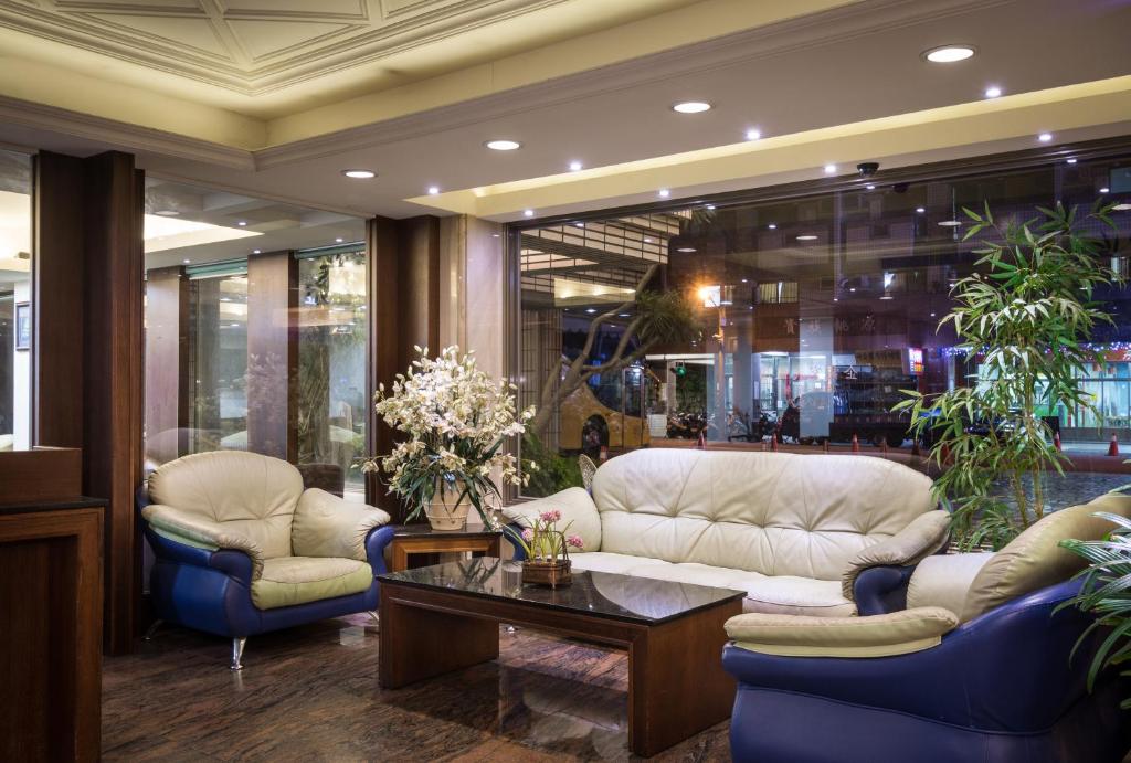 a lobby with a couch and two chairs and a table at The Enterpriser Hotel in Taichung