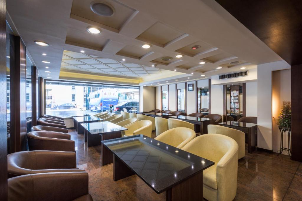 a restaurant with couches and tables and chairs at The Enterpriser Hotel in Taichung