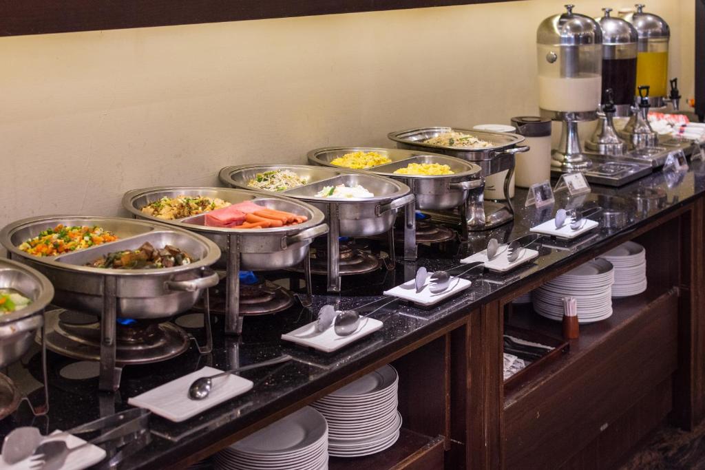 a buffet line with bowls of food on plates at The Enterpriser Hotel in Taichung