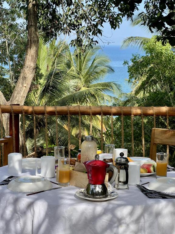 a table with a tea pot on a table with a view of the ocean at Kimulimuli Green Heaven in Kilindoni