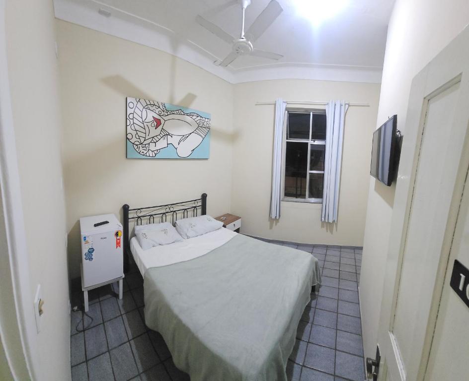 une petite chambre avec un lit et une fenêtre dans l'établissement Estação Pousada e Hostel, à Cataguases