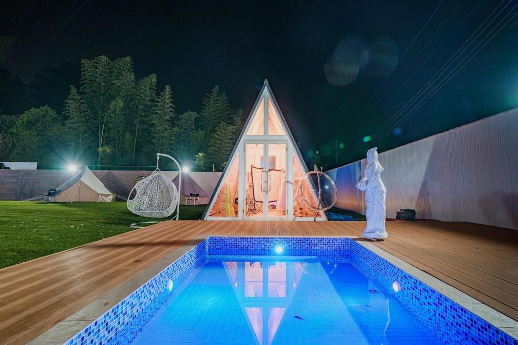 a house with a swimming pool in front of a tent at Dream Dome Glamping Studio Ichihara in Ichihara