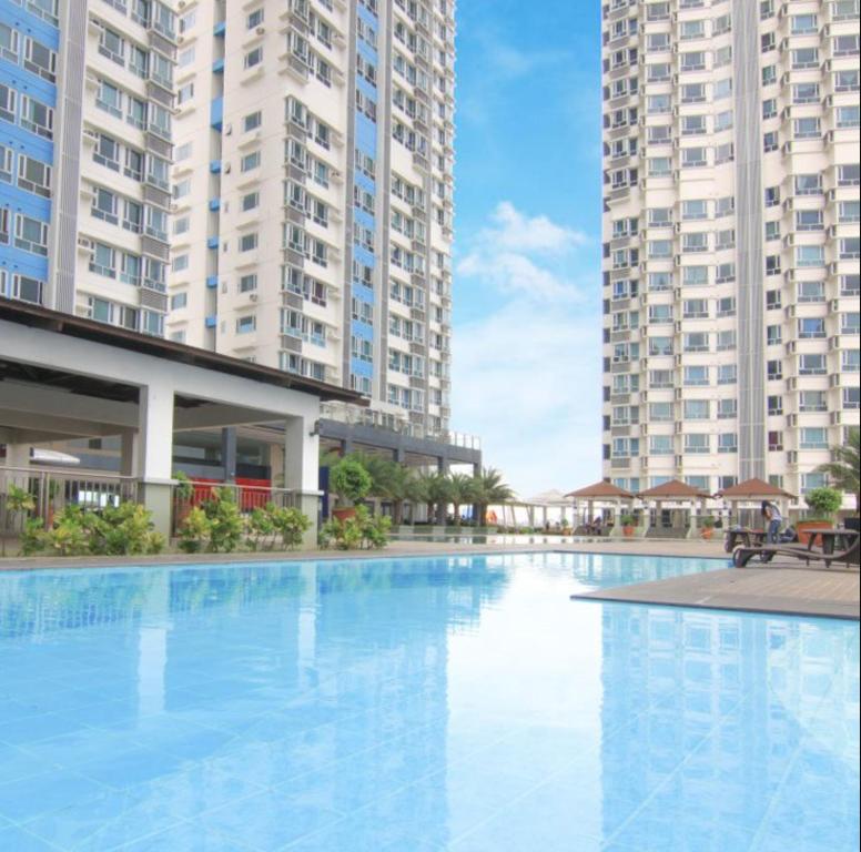 a large swimming pool with two tall buildings at Mezza Residences in Manila