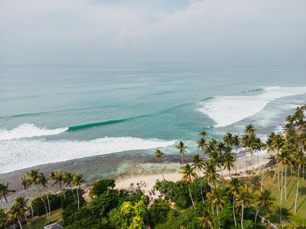 an aerial view of a beach with palm trees and the ocean at Kelani Retreat in Matara