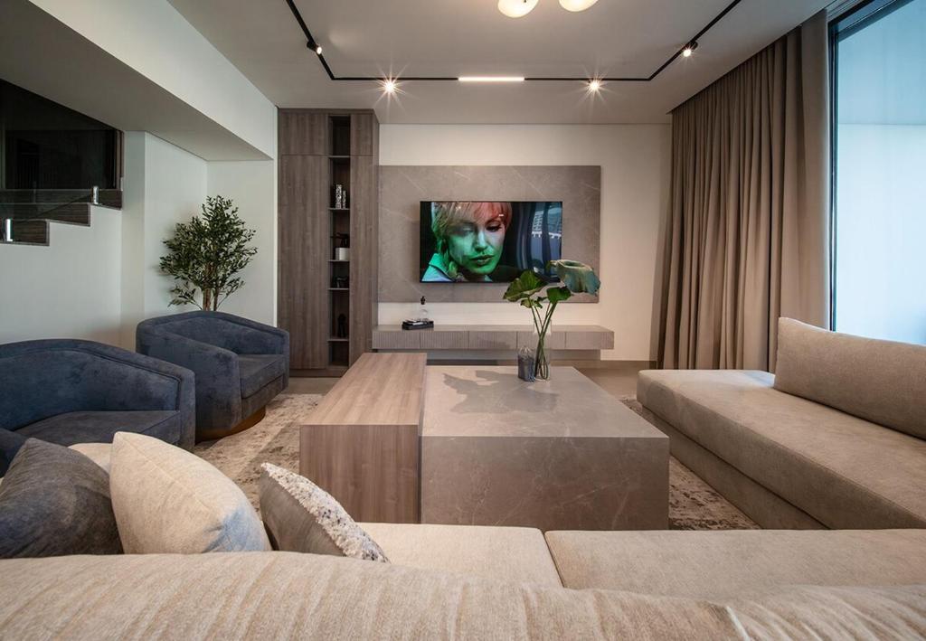 a living room with a couch and a table at Luxury Villa in Ajmal Makan with private pool in Al Ḩamrīyah