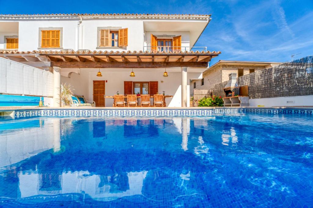 a villa with a swimming pool in front of a house at Ideal Property Mallorca - Eden Lago in Alcudia