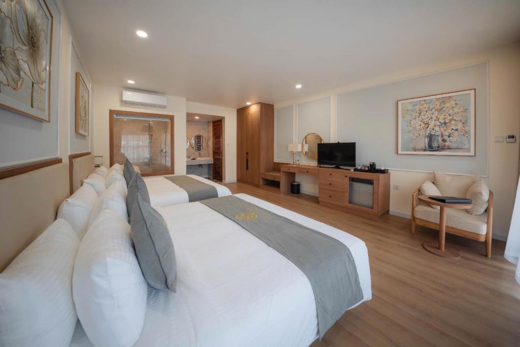 a hotel room with a large white bed with pillows at Maison Lake View Luang Prabang in Luang Prabang