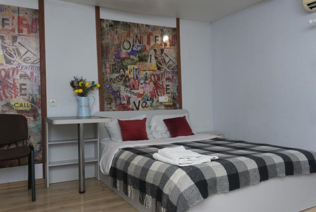 a bedroom with a bed with a black and white blanket at Студія в 5 хв від залізничного вокзалу in Kharkiv