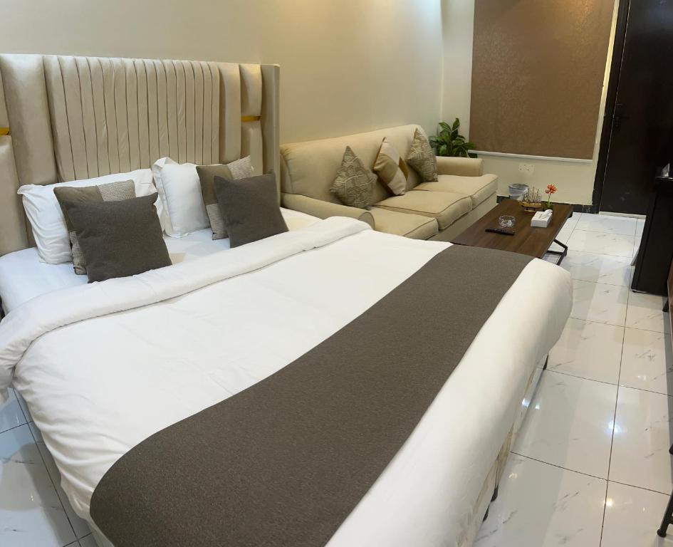 ein Hotelzimmer mit einem großen Bett und einer Couch in der Unterkunft Hala 04 استديو انيق ومستقل in Quai