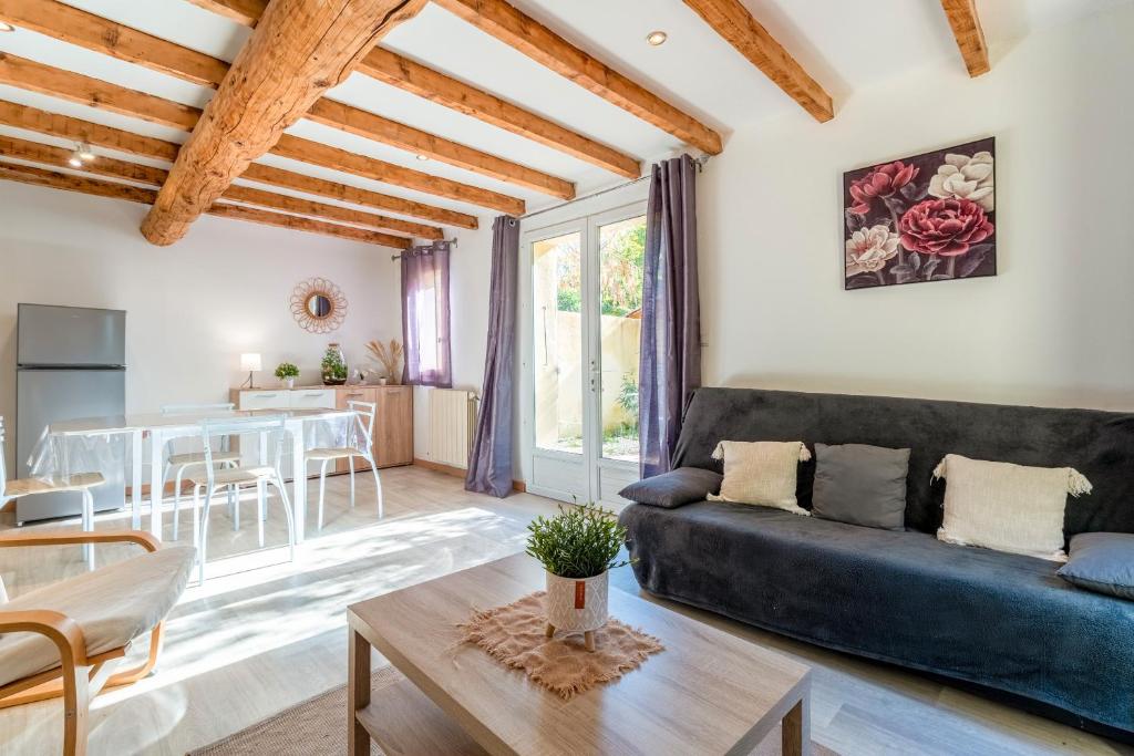 una sala de estar con un sofá y una mesa en Maisonnette Provençale, en Le Thor