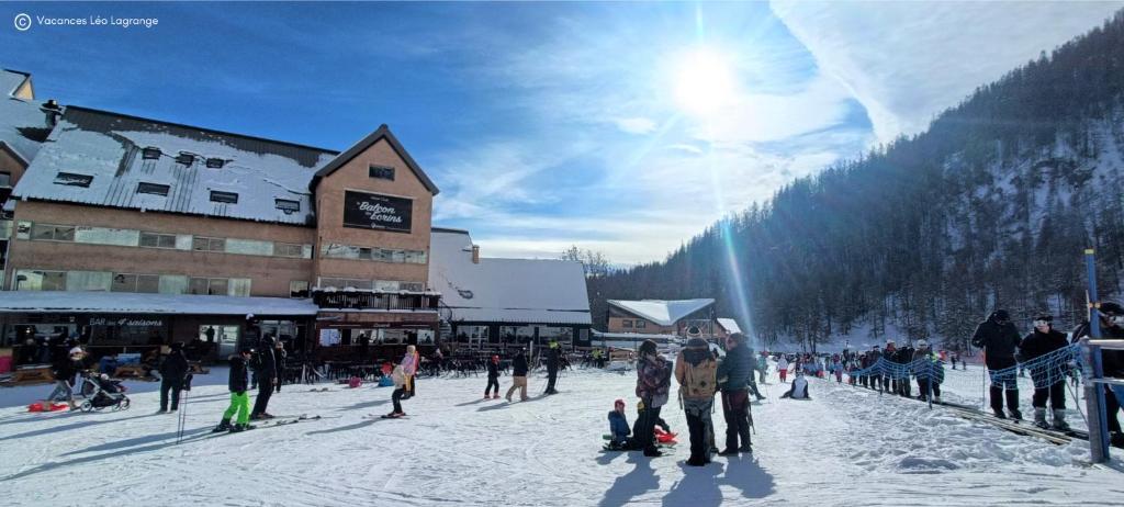un groupe de personnes debout dans la neige près d'un lodge de ski dans l'établissement Le Balcon des Ecrins, à Réallon