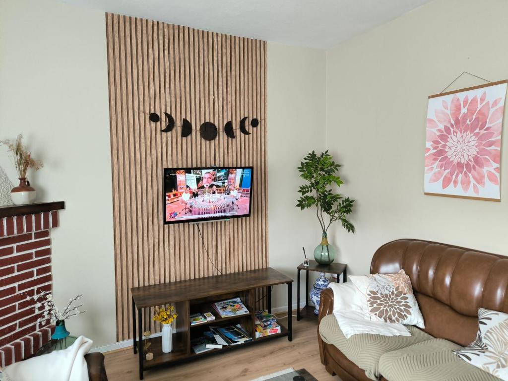 El EscobalにあるCasa las granxiasのソファと壁掛けテレビのあるリビングルーム