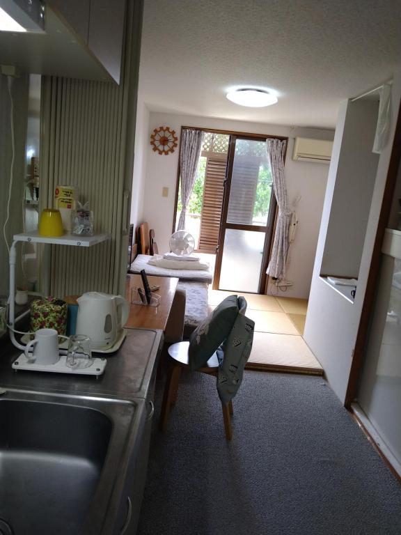a kitchen with a child sitting on a chair at Minshuku Zabaru in Ishigaki Island