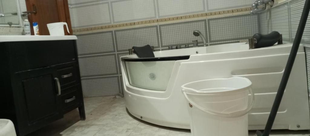 een badkamer met een bad, een toilet en een wastafel bij RESIDENCY GUEST HOUSE University Town Peshawer in Peshawar